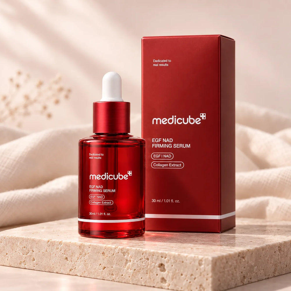 Frasco y caja rojos de Medicube EGF NAD de 30 ml, sobre un pedestal claro.