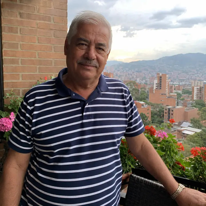 Hombre colombiano mayor en un balcón con vista urbana